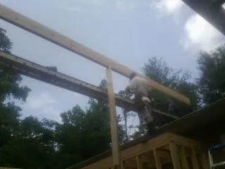 Carpenter setting a ridge beam over a new addition frame — Ice Dam Removal by Roofing Brothers in Hurricane