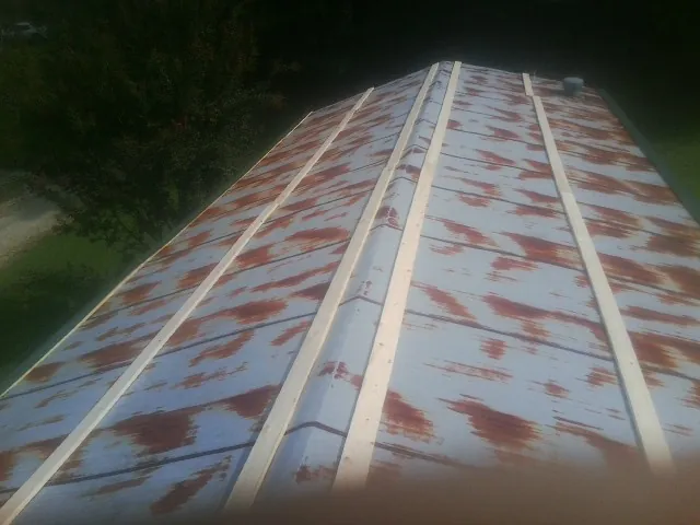 Rusted metal roof panels with new wood purlins before replacement — Storm Damage Roof Repair in Hurricane by Roofing Brothers