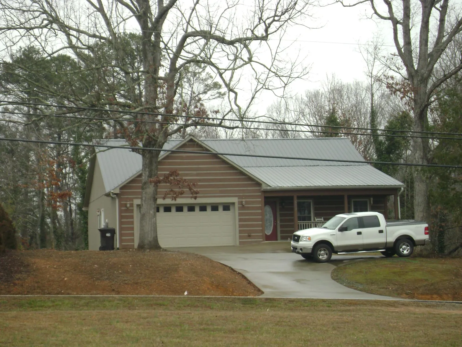 Gray metal roof on a log sided house with an attached two car garage in Hurricane